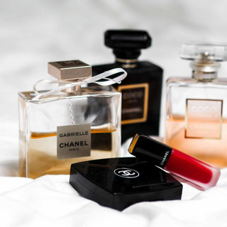 Chanel Luxus-Kosmetik und Parfüm Arrangement mit Gabrielle Parfüm, schwarzer Chanel Kompaktpuder und rotem Lippenstift auf weißem Hintergrund