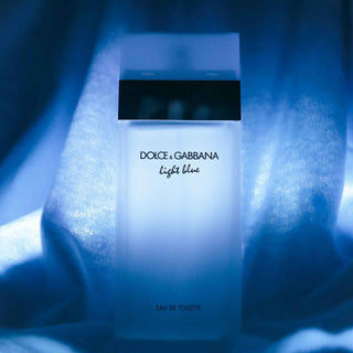 Dolce & Gabbana Light Blue Eau de Toilette Flakon in künstlerischer Beleuchtung mit blauem Hintergrund und weichem Fokus, luxuriöses Parfüm Produktfotografie