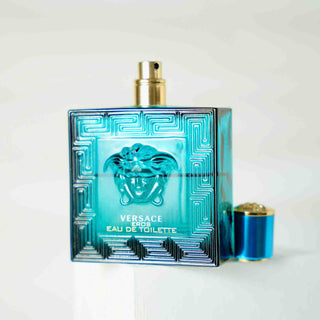 Versace Eros Eau de Toilette Flakon in türkisblauem Glas mit ikonischem Medusa-Kopf und geometrischem Muster, goldener Sprühkopf, luxuriöses Herrenparfüm auf weißem Hintergrund fotografiert